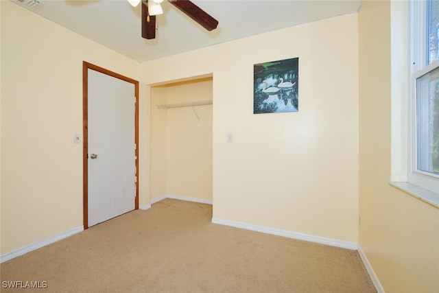 unfurnished bedroom with multiple windows, ceiling fan, and light carpet