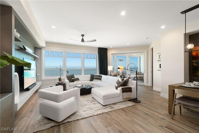 living room featuring ceiling fan and light wood-type flooring