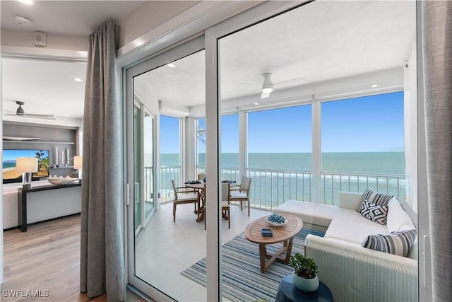 interior space featuring ceiling fan, a water view, and light hardwood / wood-style flooring