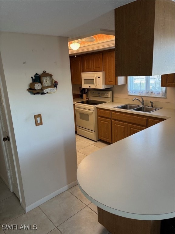 kitchen with white appliances, sink, and light tile patterned floors