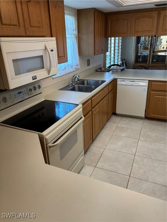 kitchen featuring sink, light tile patterned floors, and white appliances