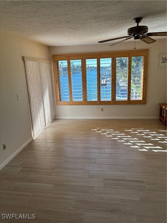 spare room featuring ceiling fan, a healthy amount of sunlight, and a textured ceiling