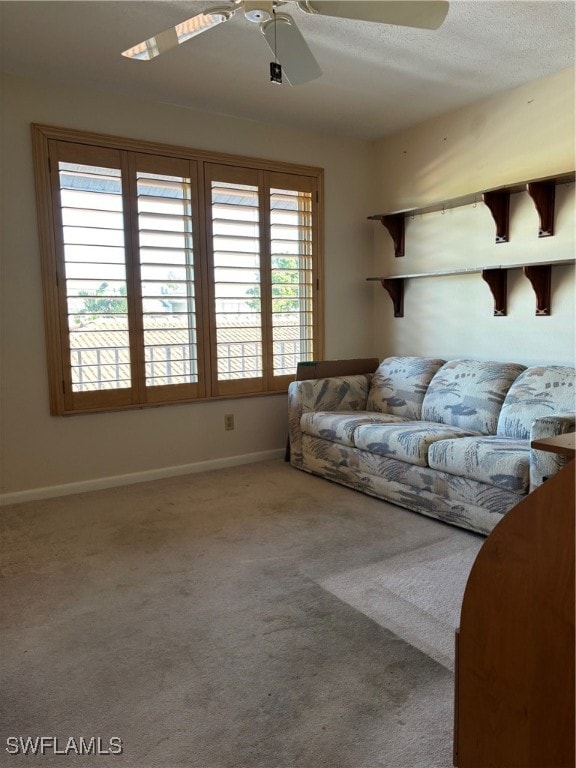 living room with ceiling fan, carpet, and a textured ceiling