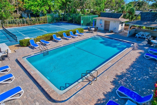 view of pool with tennis court