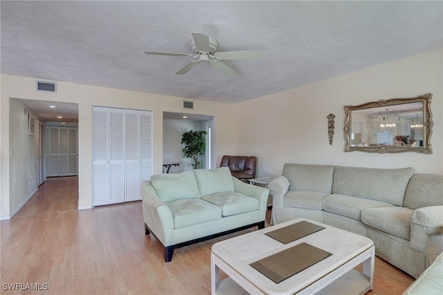 living room with ceiling fan and light hardwood / wood-style flooring