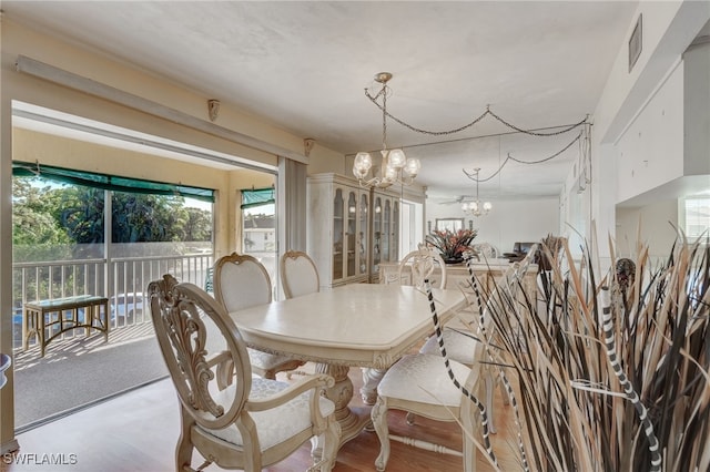 dining area featuring light wood-type flooring and an inviting chandelier