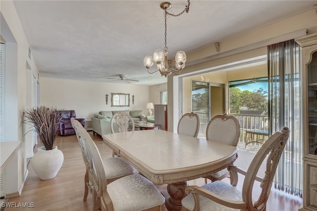 dining area with light hardwood / wood-style floors and ceiling fan with notable chandelier