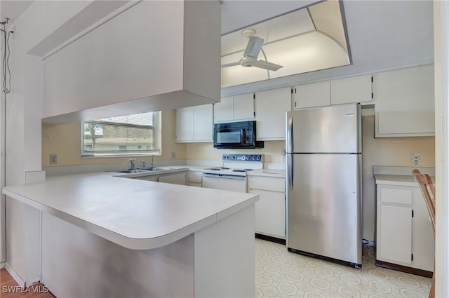 kitchen featuring white cabinets, white range with electric stovetop, kitchen peninsula, and stainless steel refrigerator