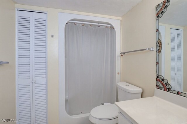 bathroom with walk in shower, vanity, and toilet