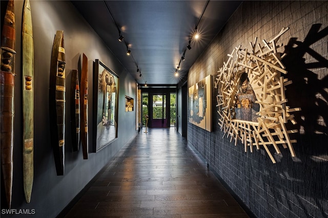 hall featuring rail lighting and dark wood-type flooring