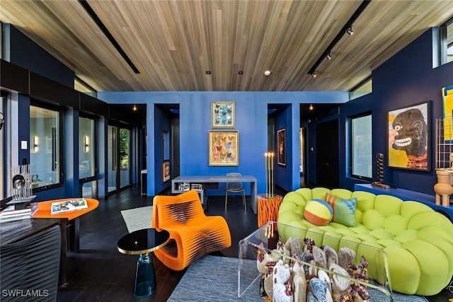 interior space with dark wood-type flooring, rail lighting, wooden ceiling, and vaulted ceiling