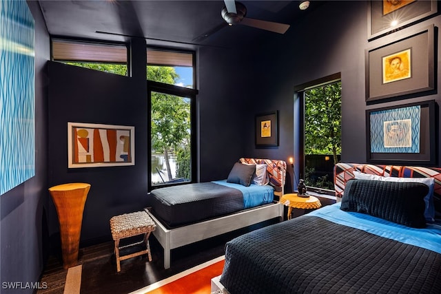 bedroom featuring ceiling fan, hardwood / wood-style floors, and high vaulted ceiling