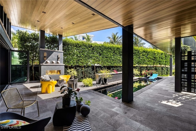 view of patio / terrace featuring an outdoor fireplace and a swimming pool