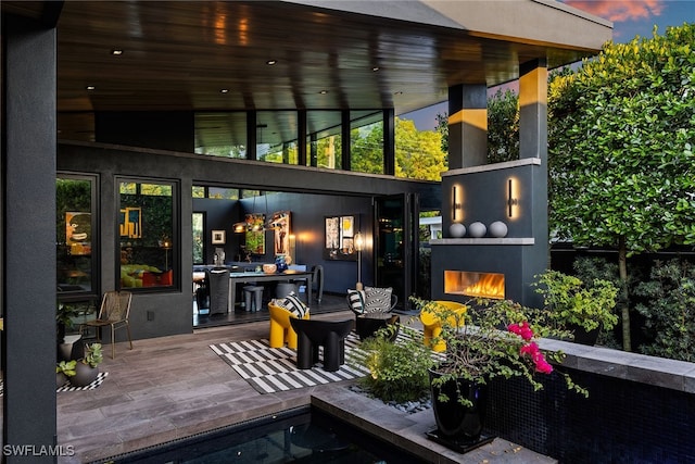 back house at dusk with an outdoor fireplace