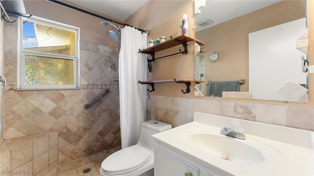 bathroom with curtained shower, vanity, and toilet