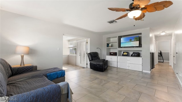 living room featuring built in shelves and ceiling fan