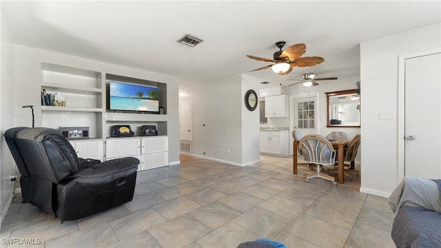 tiled living room featuring ceiling fan and built in features