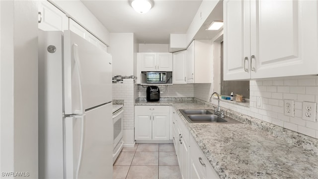 kitchen with white cabinetry, sink, light tile patterned floors, and white appliances