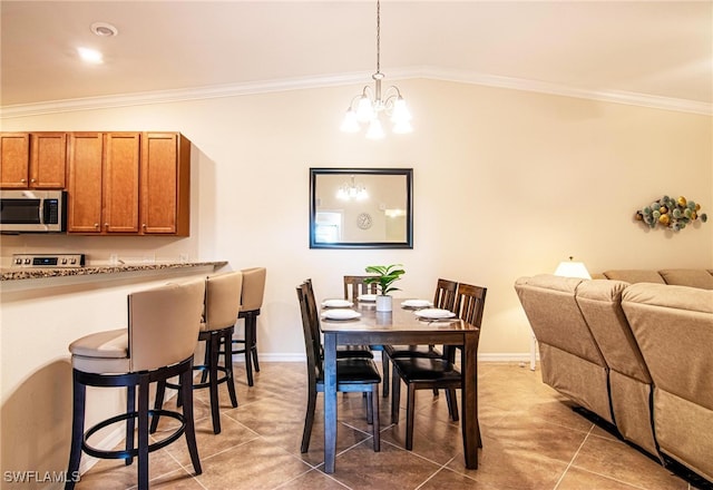 tiled dining room featuring a chandelier, ornamental molding, and lofted ceiling