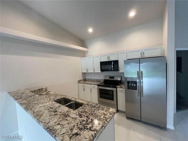 kitchen featuring sink, stone countertops, vaulted ceiling, white cabinets, and appliances with stainless steel finishes