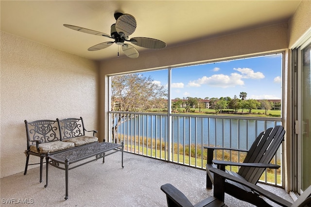 sunroom with a water view, a healthy amount of sunlight, and ceiling fan