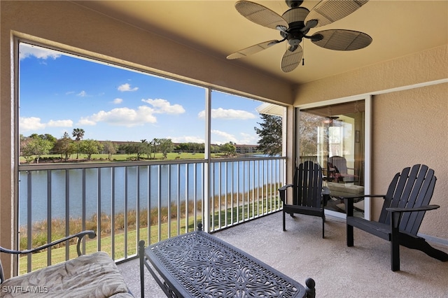 sunroom featuring a healthy amount of sunlight, ceiling fan, and a water view