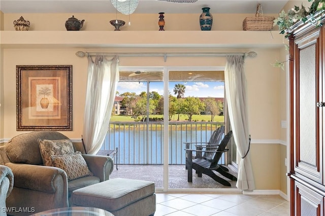 sitting room with a water view and light tile patterned floors