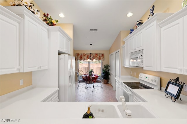 kitchen featuring hanging light fixtures, white appliances, white cabinets, and light tile patterned flooring