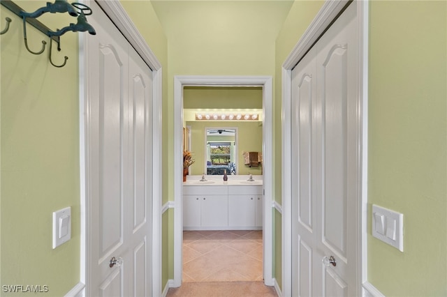 corridor with sink and light tile patterned floors