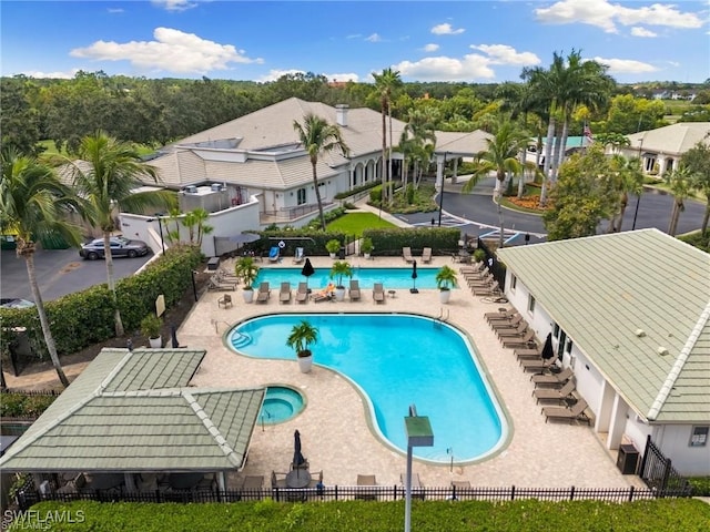 view of swimming pool with a hot tub and a patio area