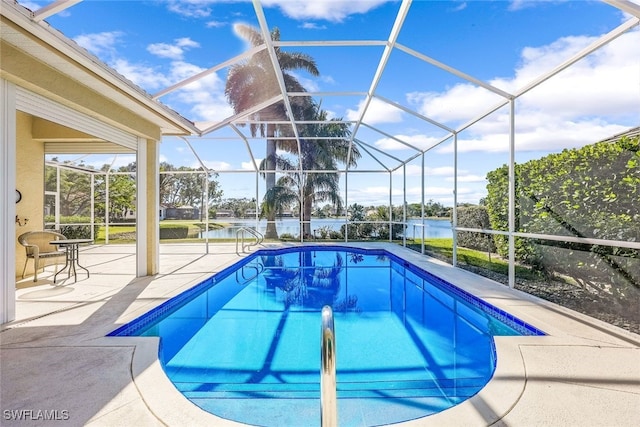 view of pool with glass enclosure, a patio area, and a water view