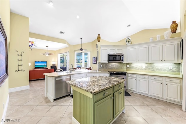 kitchen featuring white cabinets, appliances with stainless steel finishes, a center island, and lofted ceiling