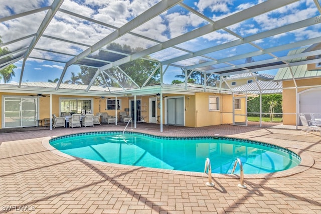 view of pool featuring ceiling fan, a patio area, and a lanai