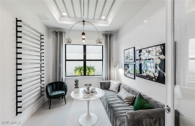 tiled living room featuring a raised ceiling and ornamental molding