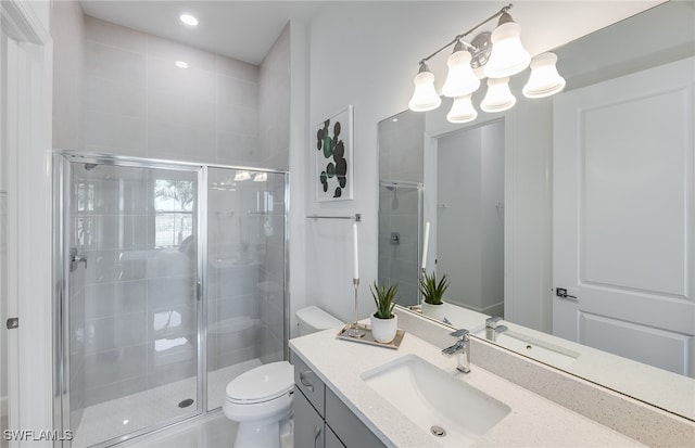 bathroom with a shower with door, vanity, and toilet