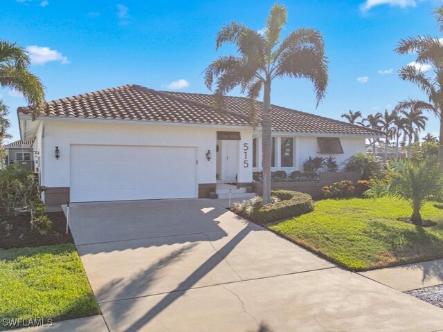 mediterranean / spanish-style home with a front yard and a garage