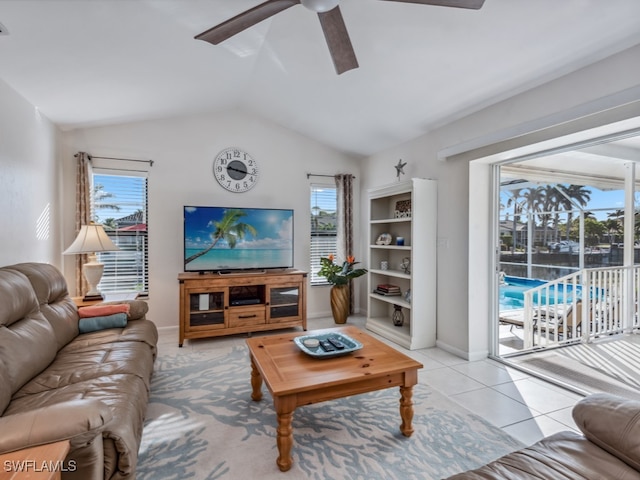 tiled living room with a wealth of natural light, ceiling fan, and vaulted ceiling