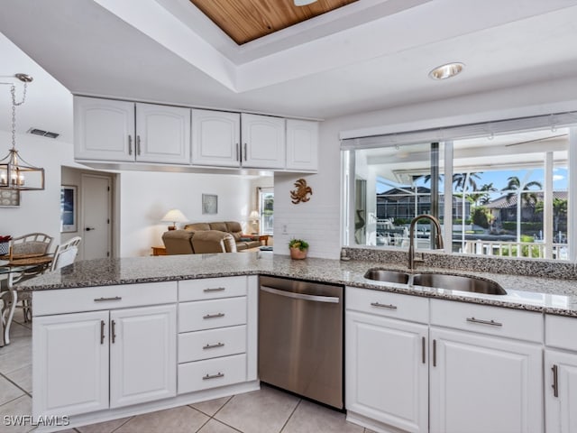 kitchen with light stone countertops, sink, light tile patterned floors, stainless steel dishwasher, and white cabinets