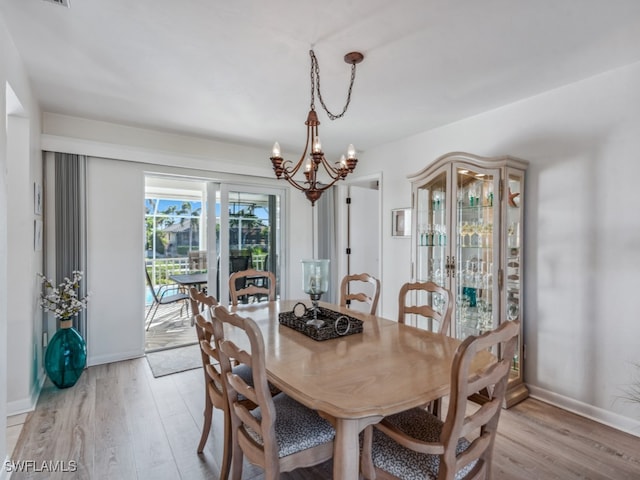 dining space with a notable chandelier and light wood-type flooring