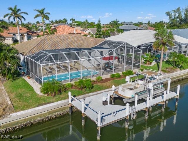 exterior space featuring a lanai, a lawn, and a water view