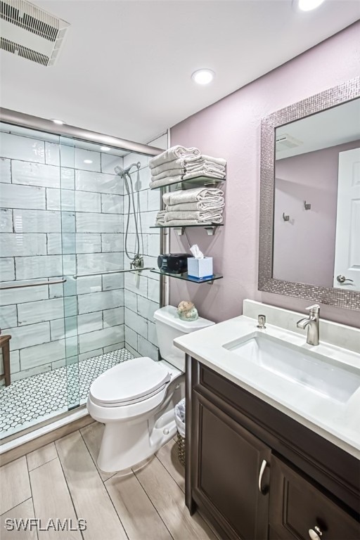 bathroom with vanity, a shower with shower door, and toilet