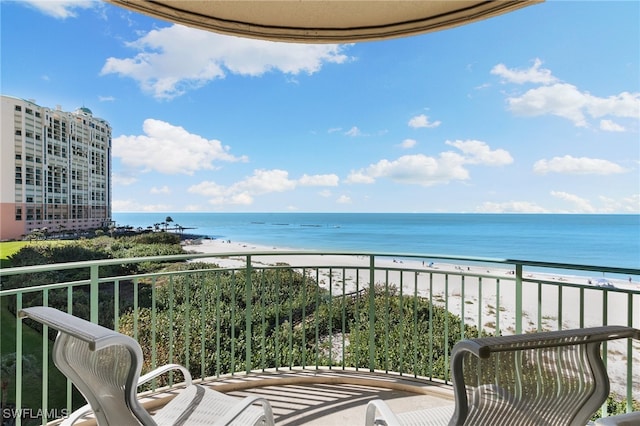 balcony featuring a view of the beach and a water view