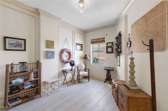 sitting room featuring light hardwood / wood-style flooring and crown molding