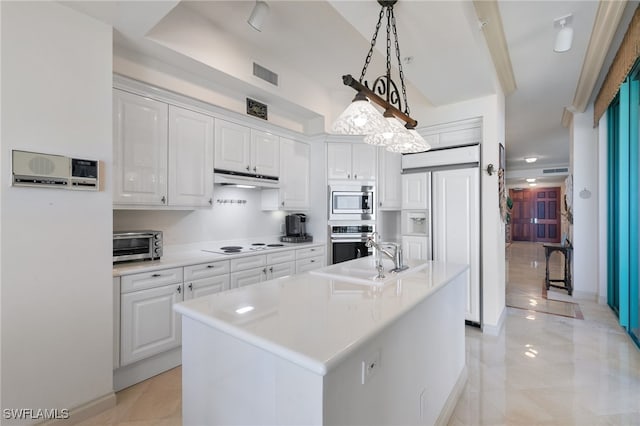 kitchen featuring built in appliances, decorative light fixtures, white cabinetry, and an island with sink