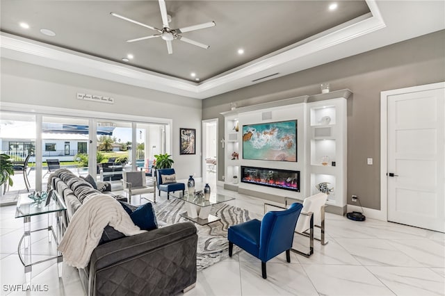 living room with a tray ceiling and ceiling fan