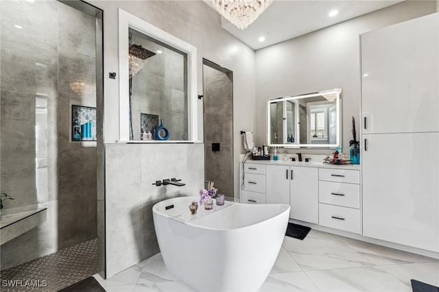 bathroom with vanity, an inviting chandelier, and separate shower and tub