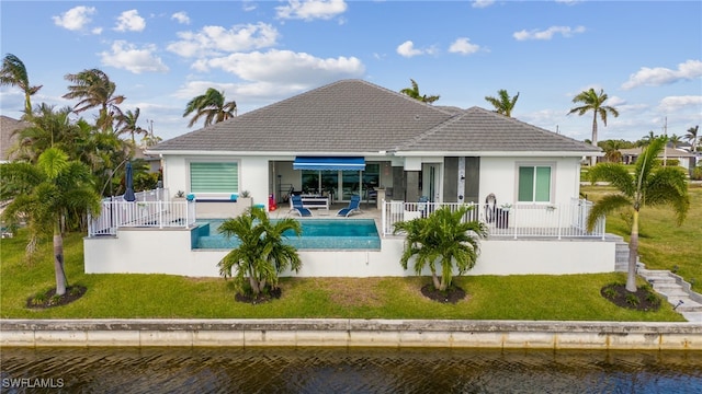 rear view of property with a patio area, outdoor lounge area, a yard, and a water view