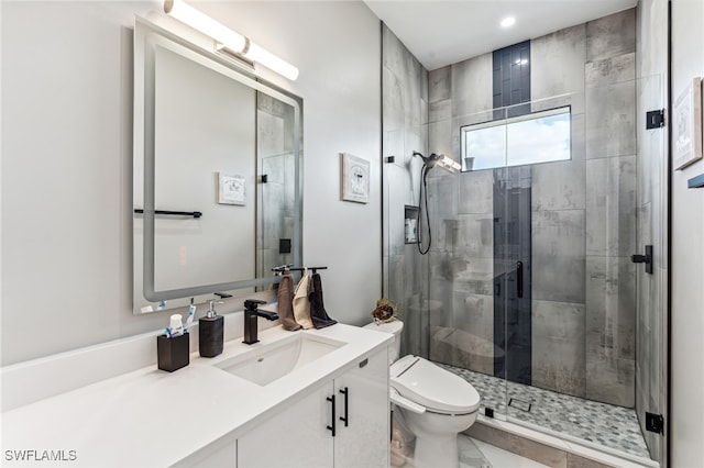 bathroom with vanity, toilet, and a shower with door