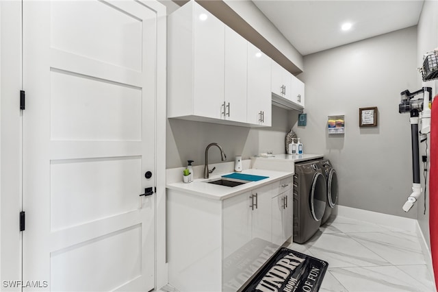 laundry area featuring separate washer and dryer, sink, and cabinets