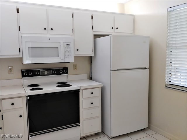 kitchen with white cabinetry, light tile patterned flooring, and white appliances